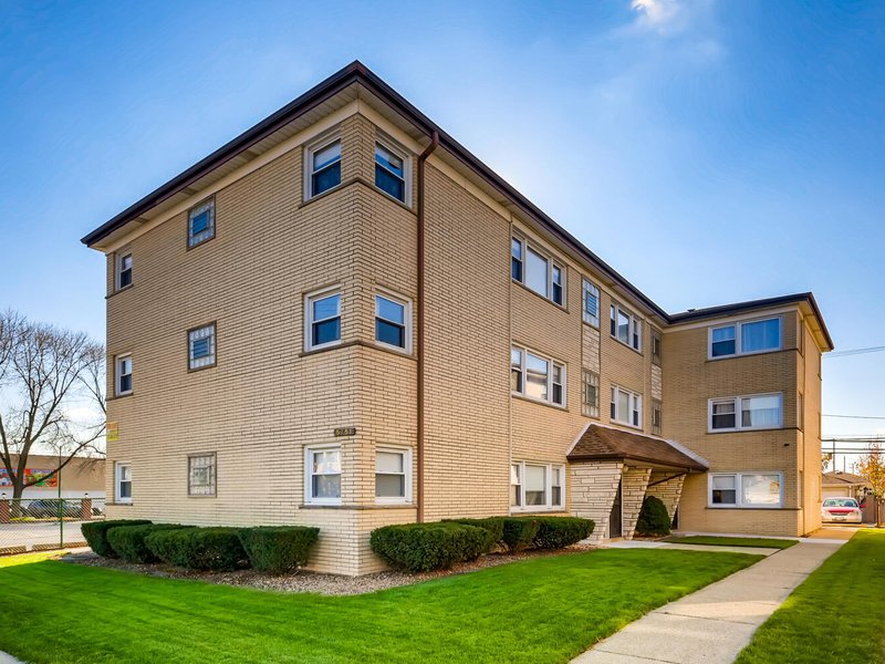 Brick garden apartment building with green lawn